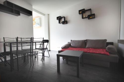 ein Wohnzimmer mit einem Sofa, einem Tisch und Stühlen in der Unterkunft Appartement 2 pièces de 48 M2 in Aix-les-Bains