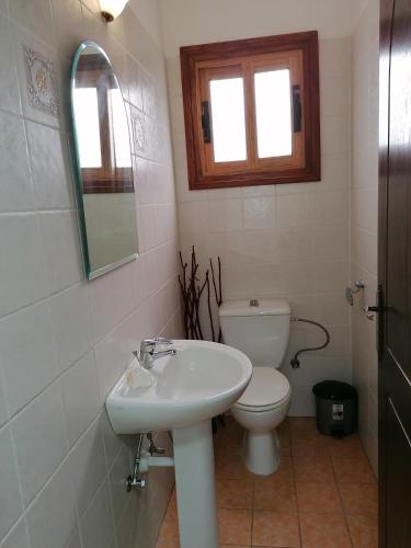 a white bathroom with a toilet and a sink at HAMBOULA in Polis Chrysochous
