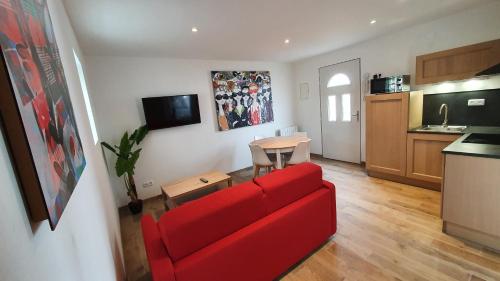 sala de estar con sofá rojo y mesa en "LE PAVILLON" Maisonnette 150 m gare des Aubrais, en Fleury-les-Aubrais