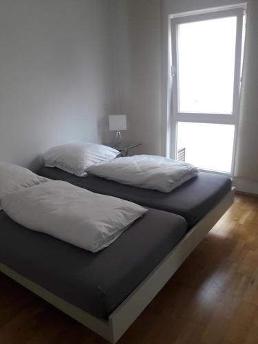 a bed with two pillows on it in a room at Ferien am Wasser in Wiesbaden