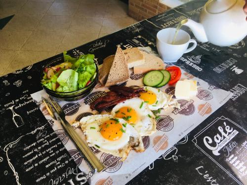 Agroturystyka Gęsiniec Stare Osieczno في Stare Osieczno: طبق من البيض والخبز مع سلطة وفنجان من القهوة