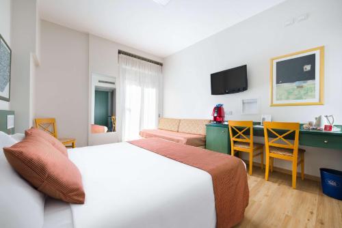 pokój hotelowy z łóżkiem, stołem i krzesłami w obiekcie Best Western Hotel Mediterraneo w Katanii