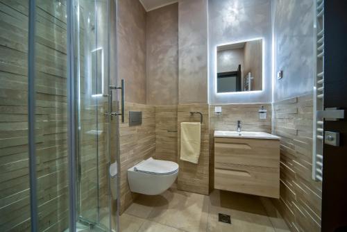 a bathroom with a toilet and a sink and a mirror at Villa Solaria in Sveti Stefan