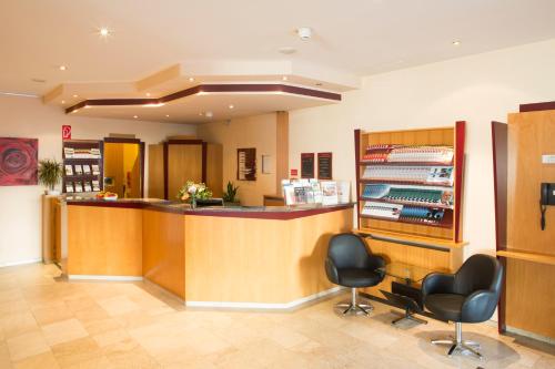 a waiting room with a counter and two chairs at Fly Inn Hotel Frankfurt Airport Rüsselsheim ehemals Trip Inn Hotels in Rüsselsheim