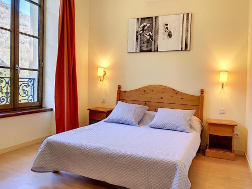 um quarto com uma cama com duas almofadas em Appartement 208 Résidence du Grand Hotel Aulus-les-Bains em Aulus-les-Bains