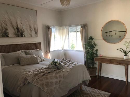 a bedroom with a bed and a mirror and a window at Moongalba Cottage in Kerry