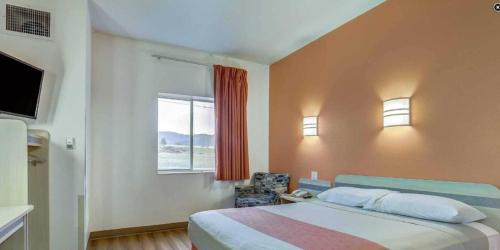 a bedroom with a large bed and a window at Motel 6-Roseburg, OR in Roseburg