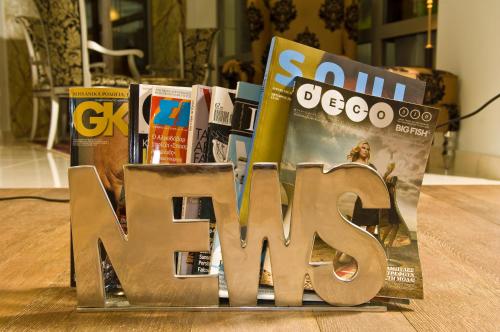 a pile of magazines on a table with the word news at Habitat Hotel in Kilkís