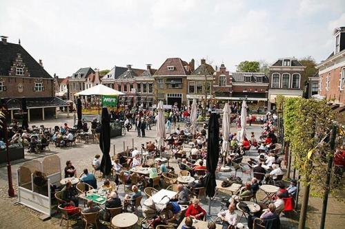 a crowd of people sitting at tables in a street at Water Villa Workum in Workum