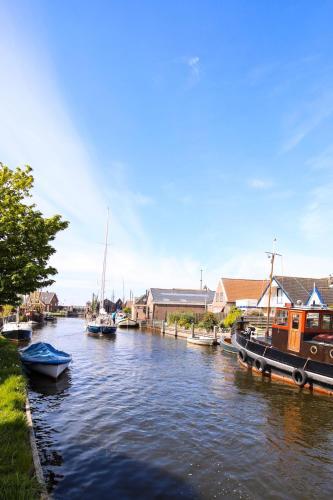 a group of boats are docked in a river at Water Villa Workum in Workum