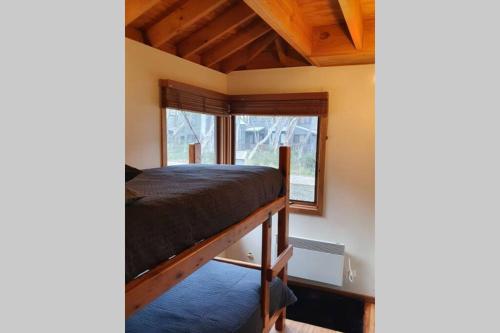 a bedroom with a bed and a window at SNOWED INN apartment in Dinner Plain