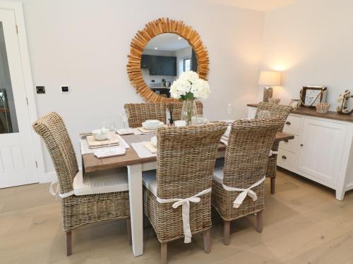 
a dining room table with two chairs and a mirror at Driftwood Haven in St Ives
