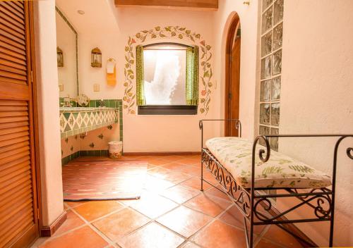 a bathroom with a chair and a window and a tile floor at Casa Estrella de la Valenciana Hotel Boutique in Guanajuato
