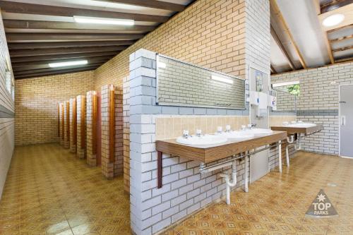 a bathroom with two sinks and two mirrors at Kalaru Holiday Park in Tathra