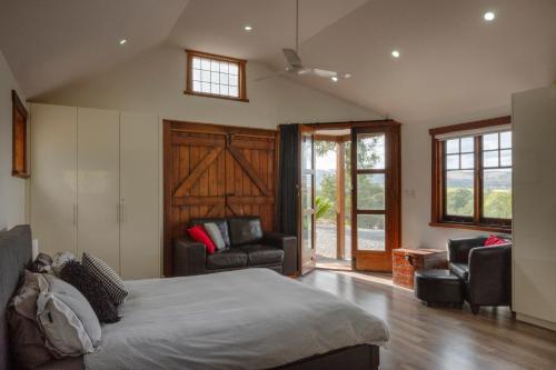 a bedroom with a bed and a couch and chairs at WayWood Wines Your Vineyard Getaway in McLaren Flat