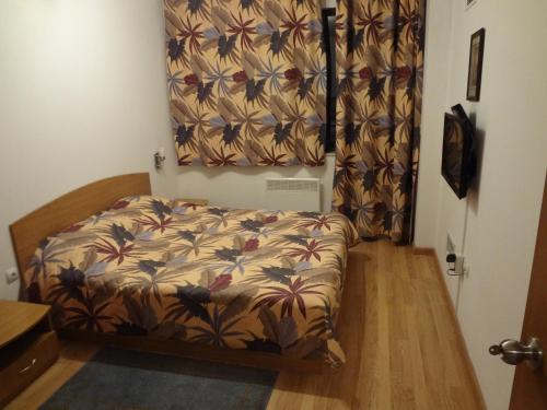 1 dormitorio con cama con cortina de flores en Deluxe Apartments, en Pamporovo