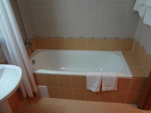 a bathroom with a white tub and a sink at Deluxe Apartments in Pamporovo