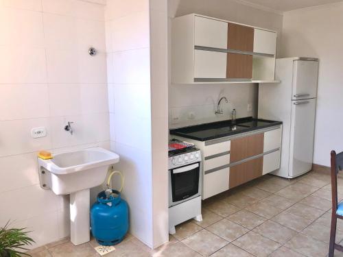 a small kitchen with a sink and a refrigerator at Apartamentos Grandes - 3 quartos com suíte in Piracicaba