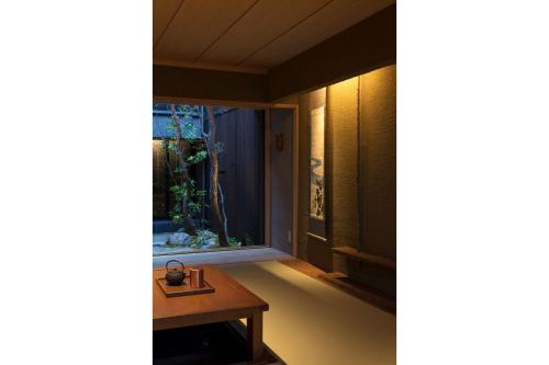 a room with a table and an aquarium in the window at Masarigusa Machiya House in Kyoto