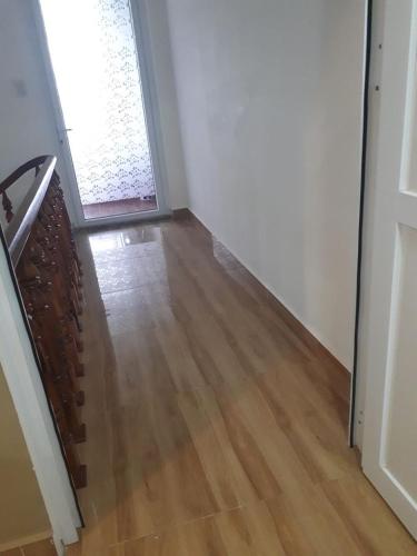 an empty hallway with a door and a wooden floor at MrLee Dalat House in Da Lat