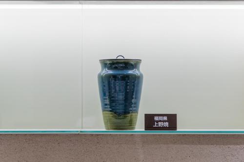 a blue vase sitting on a shelf next to a book at JR Kyushu Hotel Blossom Hakata Central in Fukuoka