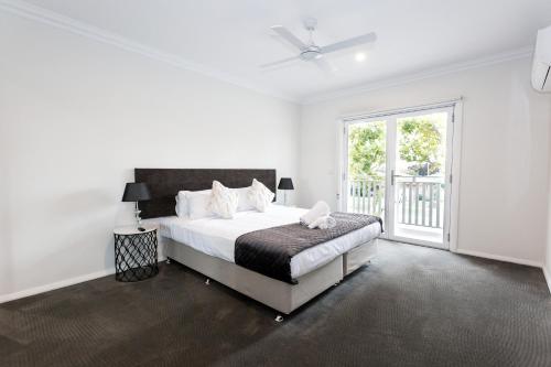 a white bedroom with a bed and a window at Wagga Apartments #5 in Wagga Wagga