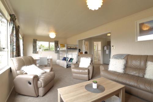 a living room with a couch and chairs and a table at Aden Motel in Te Anau