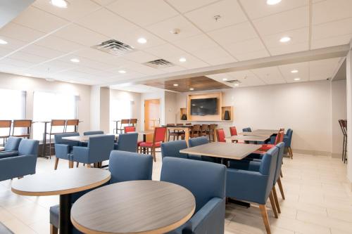 a dining room with tables and blue chairs at Holiday Inn Express Atlanta-Stone Mountain by IHG in Stone Mountain