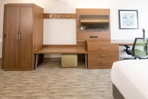 a hotel room with a desk and a tv at Holiday Inn Express Atlanta-Stone Mountain by IHG in Stone Mountain