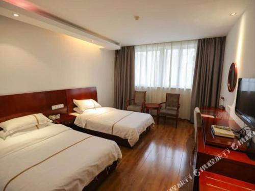 a hotel room with two beds and a television at Tianxinglou Hotel in Nanjing