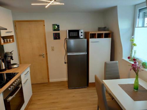 uma pequena cozinha com um frigorífico e uma mesa em Apartment Schweich-Issel Familie Lentes NEU RENOVIERT em Schweich