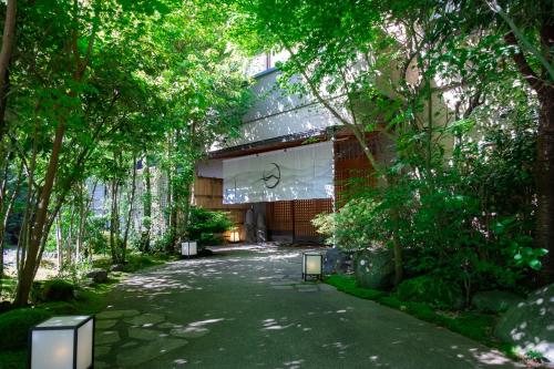 a walkway in front of a building with trees at Hakuunsou in Yugawara