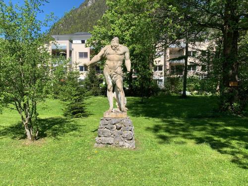 a statue of a man standing on a pile of rocks at Schlosspark Grubhof - Mitterer in Sankt Martin bei Lofer