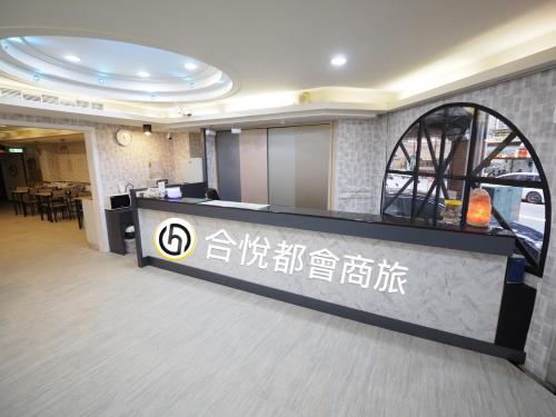 a lobby with a counter with writing on it at 合悅都會商旅 Heyue HOTEL in Hsinchu City