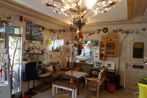 a living room with a table and a chandelier at The House Hostel in Sokcho