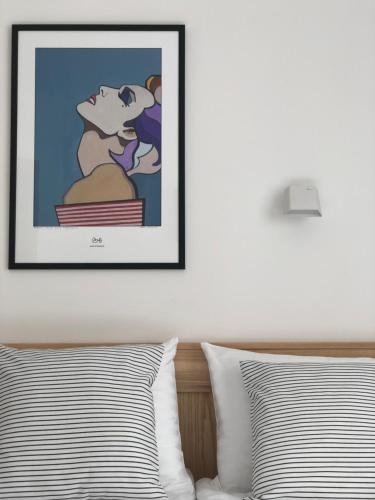a framed picture of a dog sitting on top of a bed at Astos Vila in Palanga