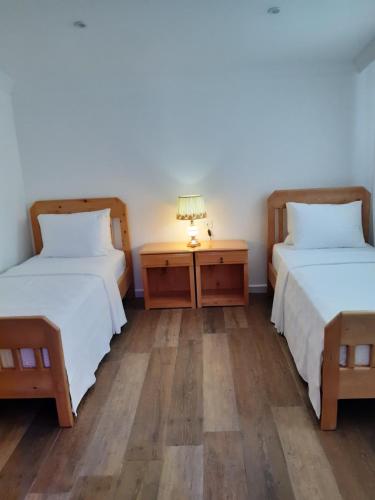 a room with two beds and a night stand with a lamp at Central Park Otel - Adult Only in Dalyan