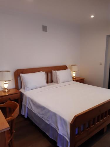 una camera da letto con un grande letto con lenzuola bianche e due lampade di Central Park Otel - Adult Only a Dalyan