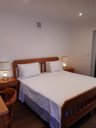 a bedroom with a large bed with white sheets and two lamps at Central Park Otel - Adult Only in Dalyan
