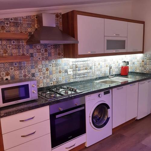 a kitchen with a washing machine and a microwave at Central Park Otel - Adult Only in Dalyan