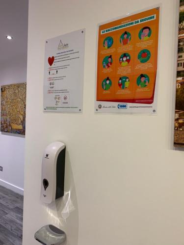 a wall with a tissue dispenser and posters on a wall at Vatican Relais Rome in Rome