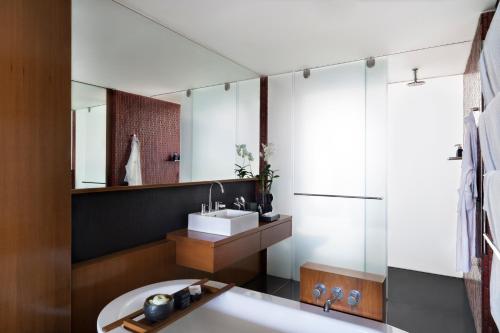 a bathroom with a tub and a sink and a mirror at Anantara Chiang Mai Resort in Chiang Mai
