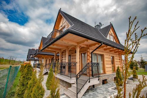 a small wooden house with a black roof at Domki Pod Jemiołą in Zakopane