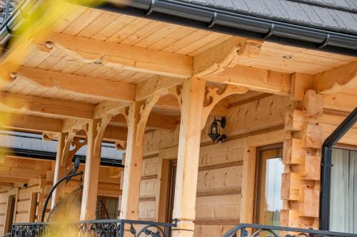 a wooden house with awning on the side of it at Domki Pod Jemiołą in Zakopane
