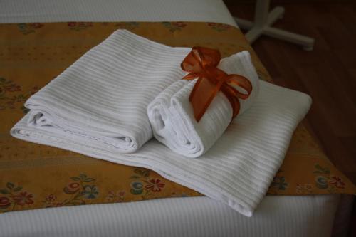 a stack of towels with a bow on a bed at Residence Ancona in Ancona