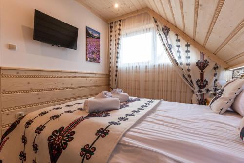 a bedroom with a bed with a television on the wall at Domki Pod Jemiołą in Zakopane