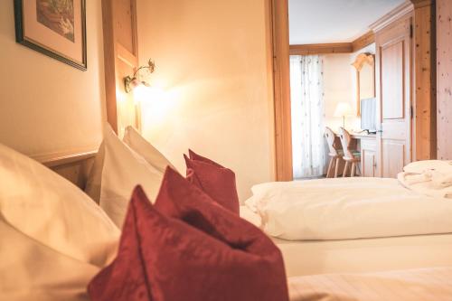 a hotel room with two beds with red pillows at Hotel Schartner in Altenmarkt im Pongau
