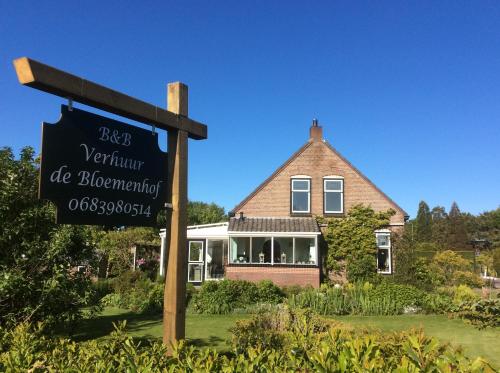 a sign in front of a house with a building at de Bloemenhof in Ouddorp