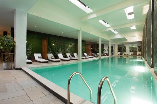 a large swimming pool in a hotel with chairs at Le Centell Hotel & Spa in Antananarivo
