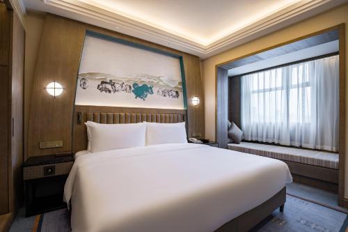 a large white bed in a room with a window at Chengdu Tibetan Hotel-Free Welcome Tibetan Tea in Chengdu
